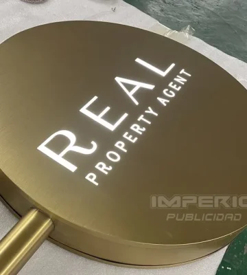 Letrero luminoso de aluminio oro cepillado con letras caladas e iluminación blanca interior