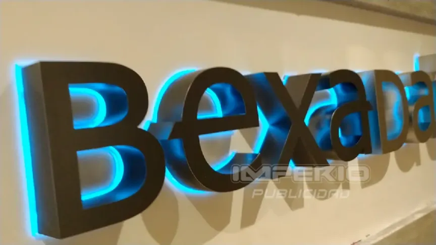 Letras 3D con iluminación halo LED azul instaladas en muro interior