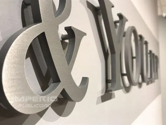 Letras de acero inoxidable cortadas en placa con separadores para instalación en muro