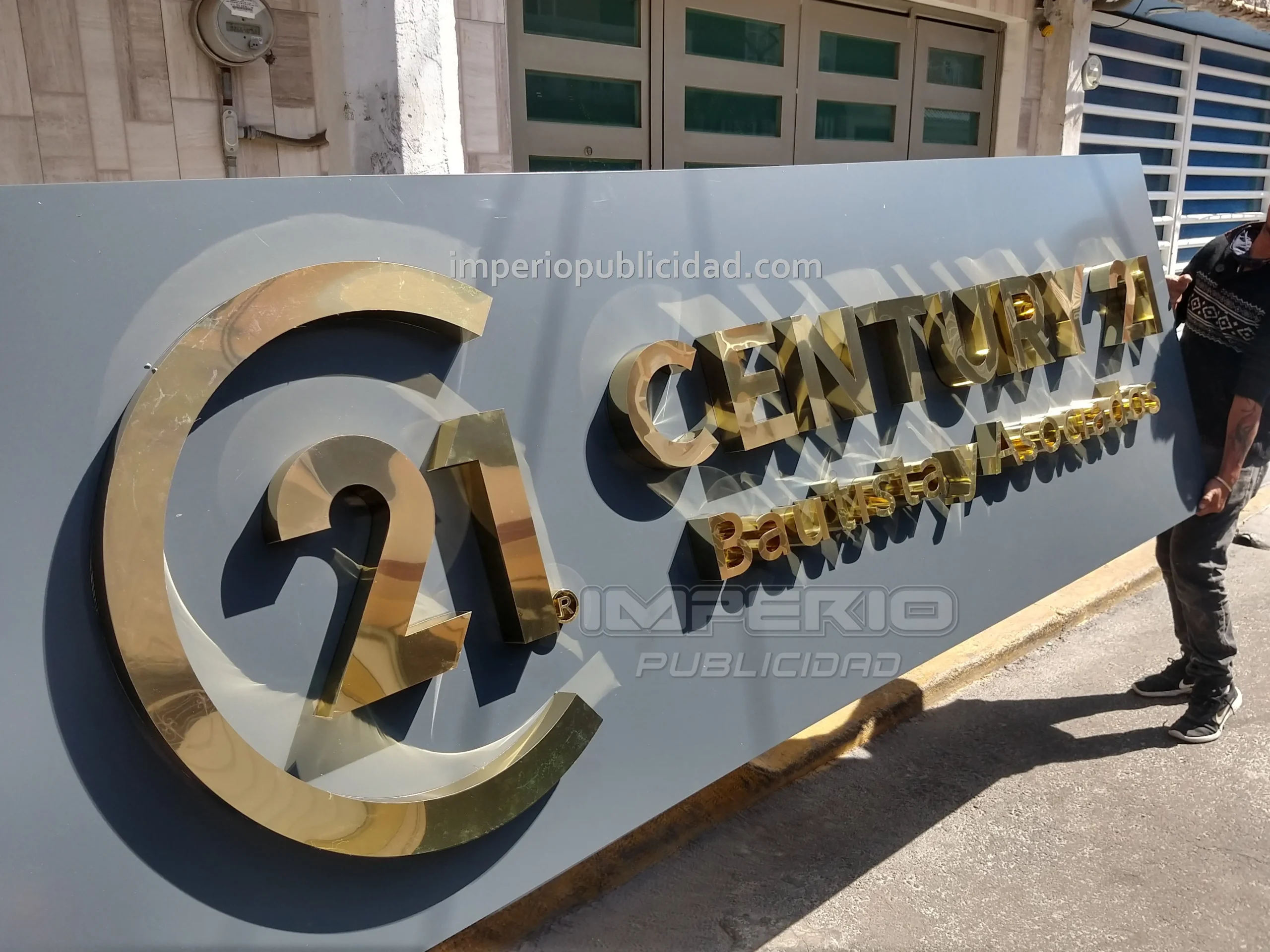 Letras 3D de aluminio dorado Century 21 instaladas en fachada de oficina