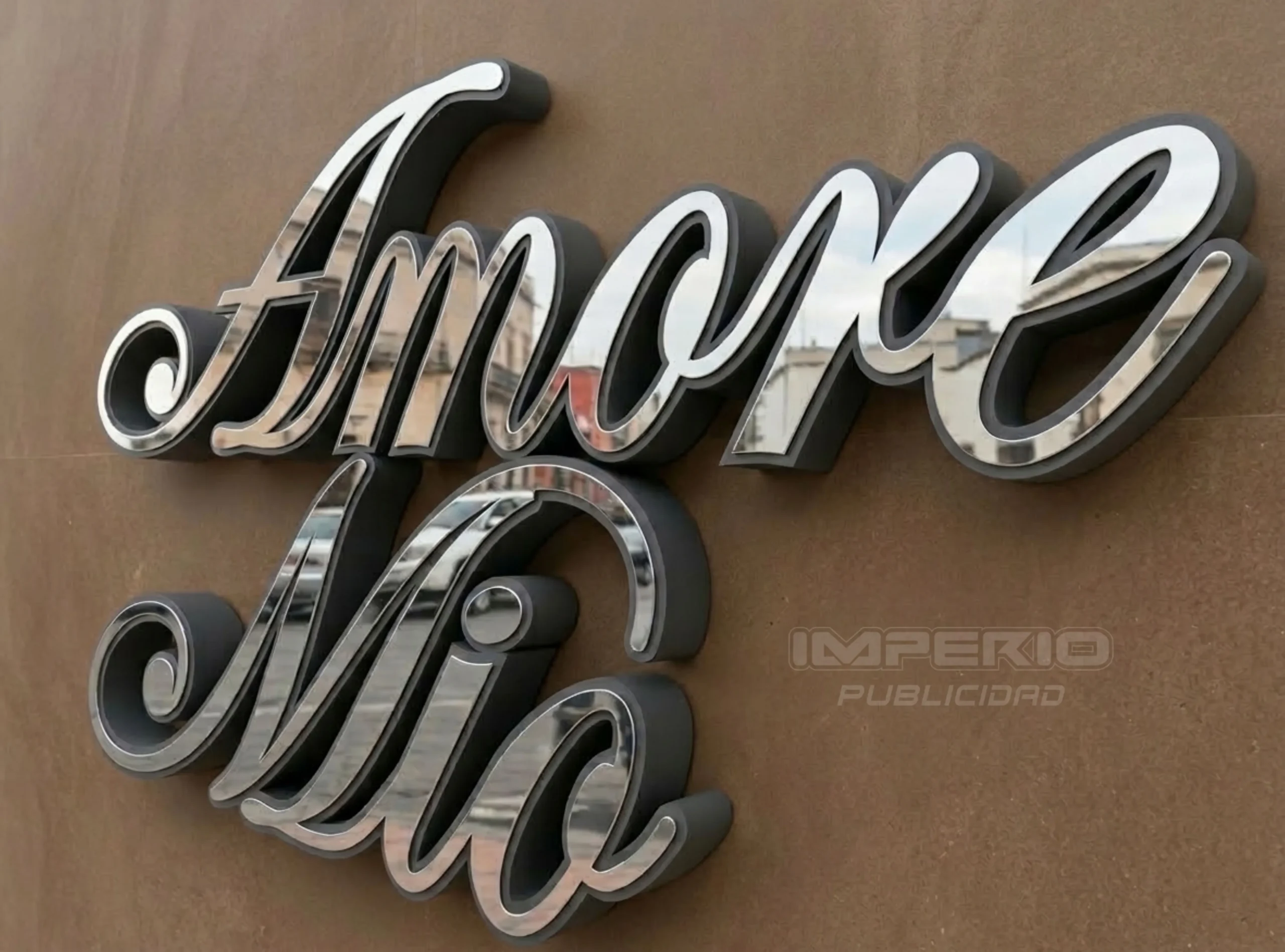 alt: letreros 3d de acero inoxidable espejo con letras cursivas instaladas en fachada con acabado elegante