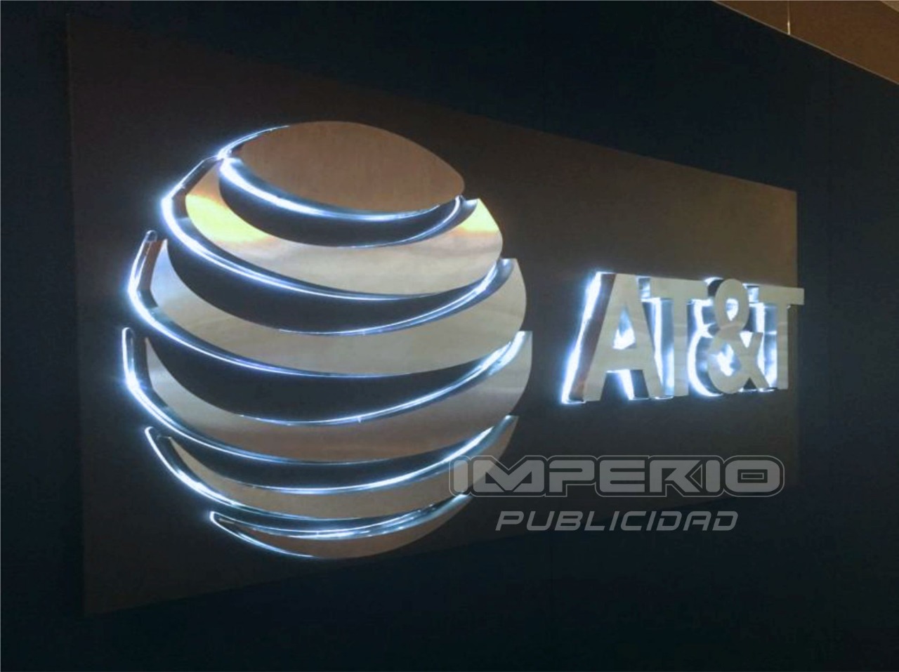 Logotipo 3D de acero inoxidable con iluminación halo LED en pared para empresa corporativa en CDMX
