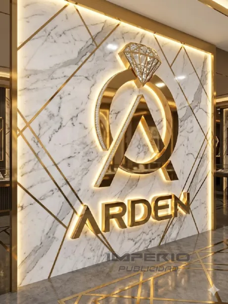Logotipo 3D dorado iluminado con LED sobre muro decorativo moderno